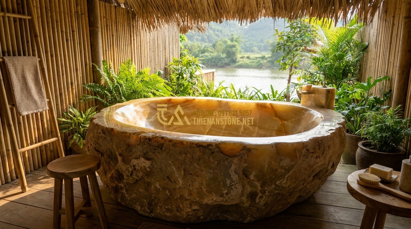 Tạo ảnh tiếng Anh: A rustic river stone bathtub carved from a single massive boulder. The exterior is rough and natural, while the interior is polished to a smooth finish. It is placed in an open-air bathroom with bamboo walls. Organic and eco-friendly design style.