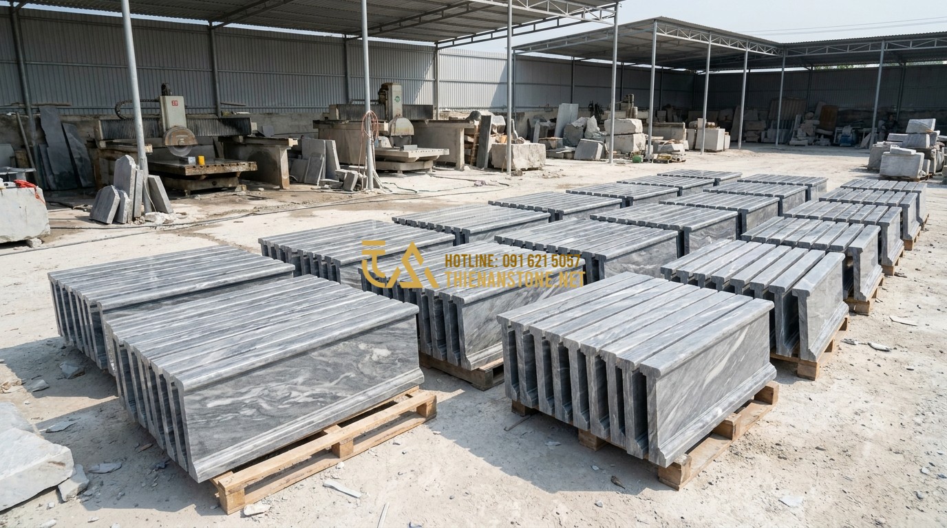 Tạo ảnh tiếng Anh: A wide panoramic shot of the Thien An Stone workshop in Phu Tho, showing dozens of finished stone balustrade sections neatly arranged for shipping. Professional and organized industrial atmosphere, bright daylight, showcasing scale and quality.