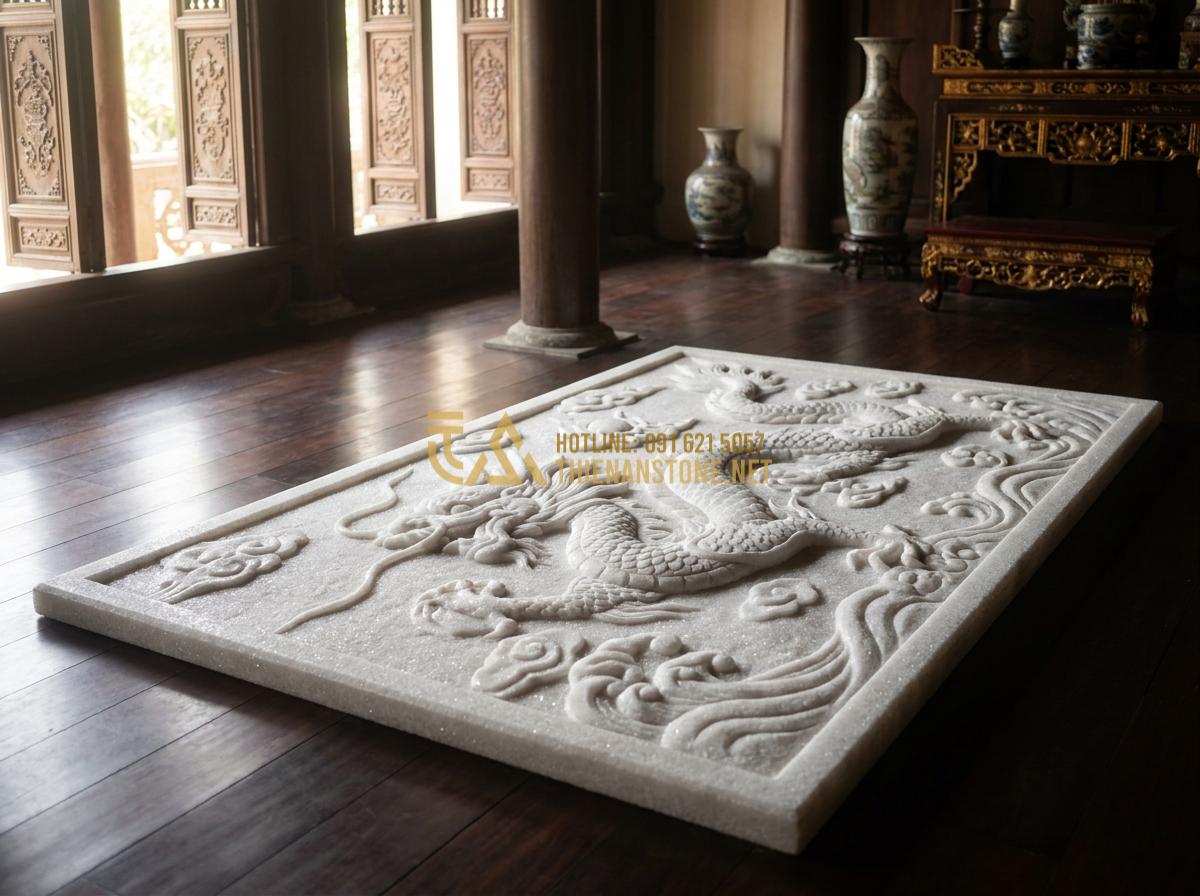 Tạo ảnh tiếng Anh: Professional high-resolution photograph of an intricately carved natural stone dragon mat with detailed dragon motifs in dynamic flying pose, placed elegantly on a polished floor in a traditional Vietnamese ancestral hall, soft natural sunlight filtering through windows, realistic textures of stone veins and carved scales, luxurious and serene atmosphere, 8k detail, cinematic lighting