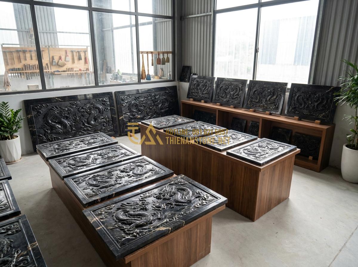 Tạo ảnh tiếng Anh: Wide angle professional shot of various sizes of natural stone dragon mats arranged in a stone art workshop showroom at Thien An Stone, showing different stone colors and dragon carvings, bright natural daylight, clean and organized display with tools in background, realistic documentary style photography