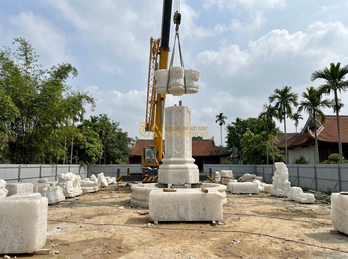 Báo Giá Đài Phun Nước Bằng Đá 2026: Chi Tiết Giá Mini, Nguyên Khối & Đá Mỹ Nghệ - Hình 18 Báo Giá Đài Phun Nước Bằng Đá 2026: Chi Tiết Giá Mini, Nguyên Khối & Đá Mỹ Nghệ - On-site construction process of large stone fountain with crane and skilled work