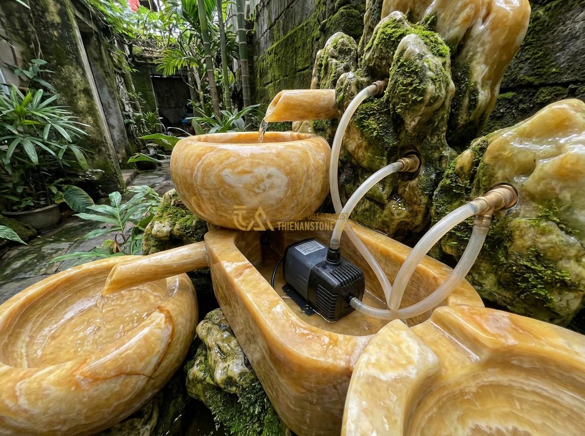 Cấu Tạo Đài Phun Nước Bằng Đá Tự Nhiên & Nguyên Lý Hoạt Động Chi Tiết - Hình 3 Cấu Tạo Đài Phun Nước Bằng Đá Tự Nhiên & Nguyên Lý Hoạt Động Chi Tiết - Internal mechanism of a stone fountain showing submersible pump, water pipes, an