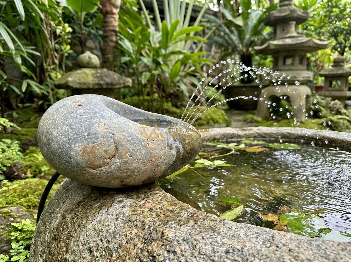 Cấu Tạo Đài Phun Nước Bằng Đá Tự Nhiên & Nguyên Lý Hoạt Động Chi Tiết - Hình 6 Cấu Tạo Đài Phun Nước Bằng Đá Tự Nhiên & Nguyên Lý Hoạt Động Chi Tiết - Close-up of carved stone nozzle and water spray patterns from a granite fountain
