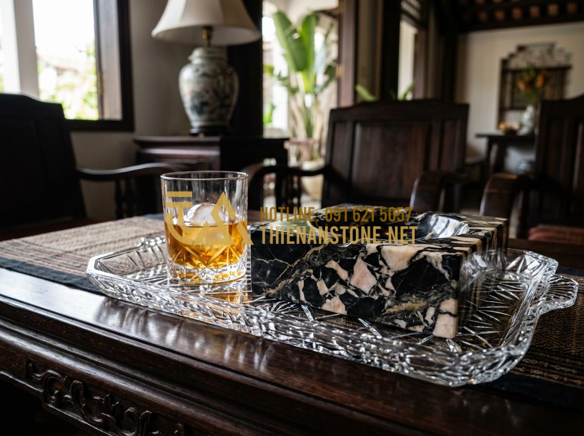 Gạt tàn độc đáo bằng đá tự nhiên: Món quà tặng sếp tinh tế và sang trọng - A clean and polished black stone ashtray sitting next to a glass of whiskey on a