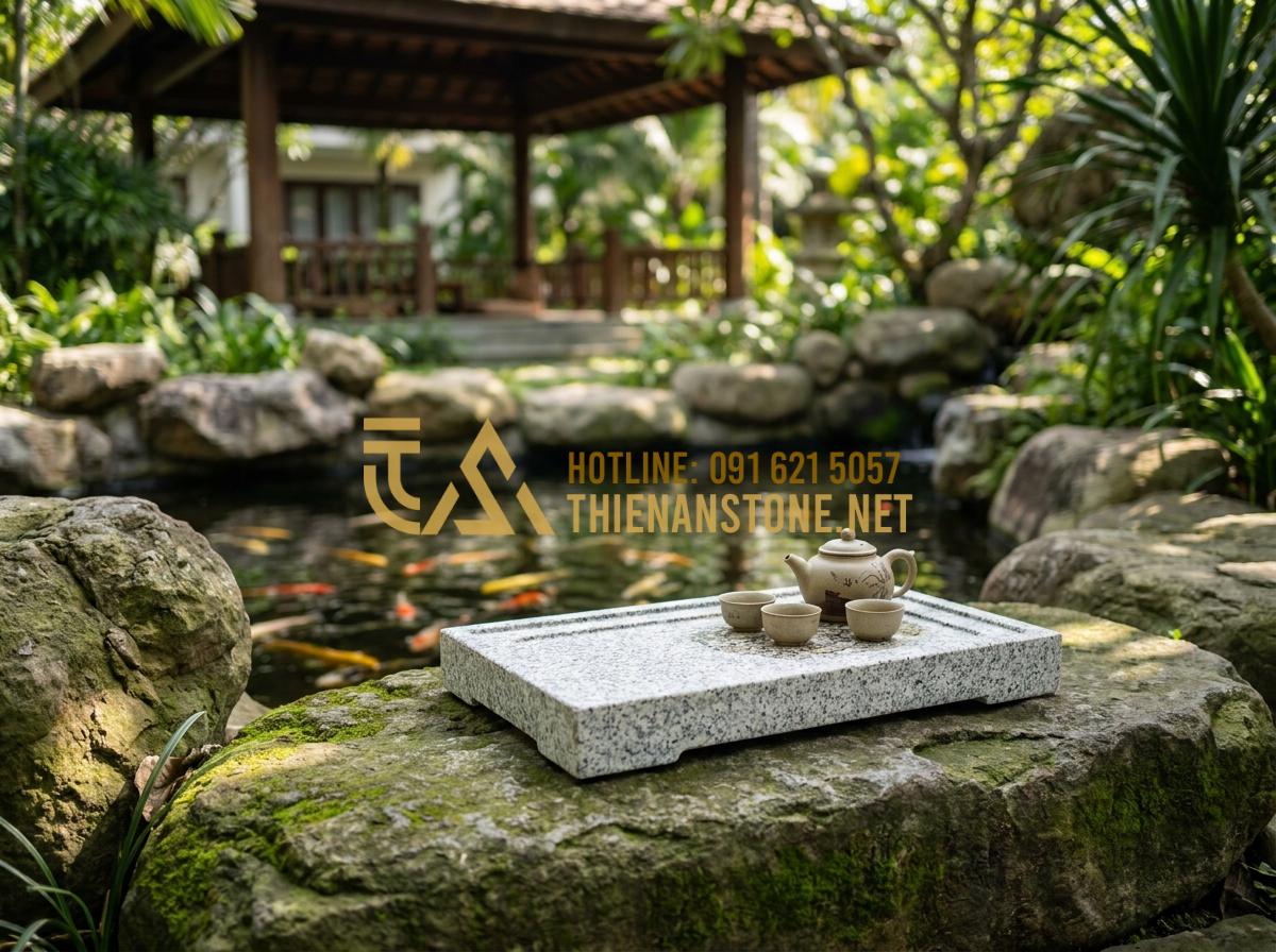 Khay Trà Đá Hoa Cương (Granite): Sự Lựa Chọn Vĩnh Cửu Cho Mọi Không Gian - Hình 13 Khay Trà Đá Hoa Cương (Granite): Sự Lựa Chọn Vĩnh Cửu Cho Mọi Không Gian - Granite tea tray integrated into a luxury resort garden setting with Koi pond an