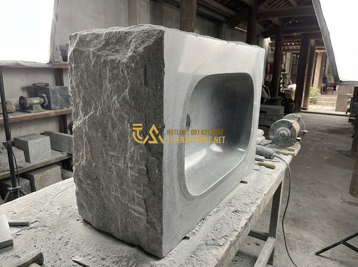 Lavabo Đá Tự Nhiên Đẹp Cao Cấp: Top Mẫu Hot Nhất 2024 & Bảng Giá Chi Tiết - Tạo ảnh tiếng Anh: A single, solid block of grey granite being transformed into