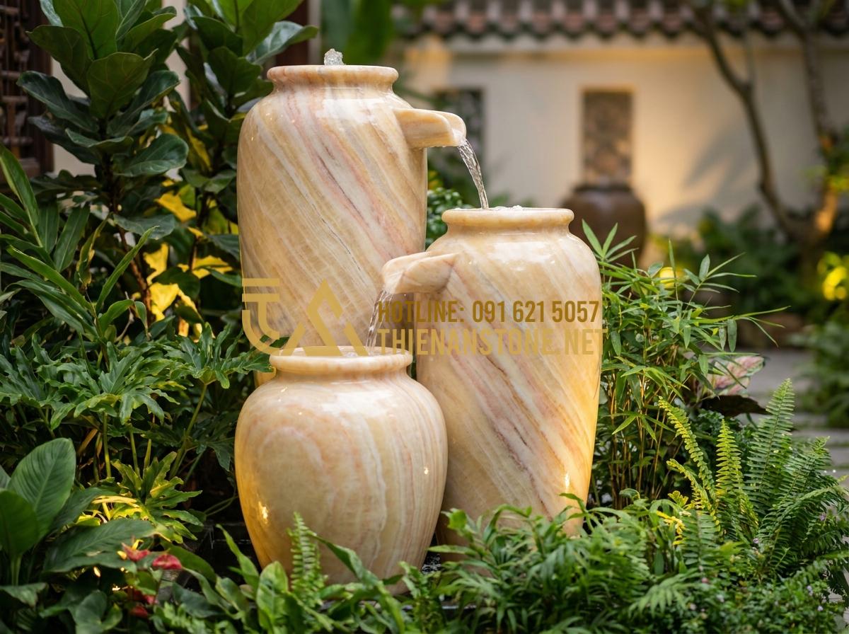 Lu nước phong thủy: Bí quyết đặt lu nước trước nhà để rước tài lộc, vượng khí - Hình 4 Lu nước phong thủy: Bí quyết đặt lu nước trước nhà để rước tài lộc, vượng khí - Tạo ảnh tiếng Anh: A sequence of three stone jars of varying heights forming a d