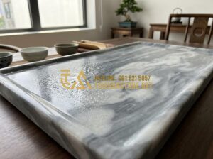 Mẹo Vệ Sinh Khay Trà Đá Luôn Sáng Bóng Như Mới Không Phải Ai Cũng Biết - Close-up view of a polished natural stone tea tray with water droplets glistenin