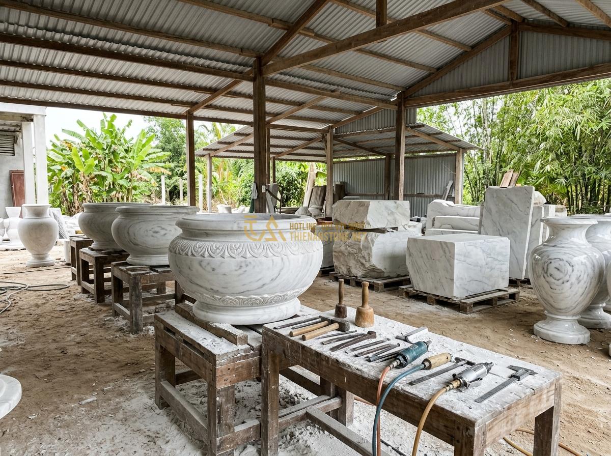 Mua Ang Nước Bằng Đá Tự Nhiên Ở Đâu Uy Tín? Địa Chỉ Chất Lượng Giá Tốt - Professional stone workshop interior showing workers carving large natural stone