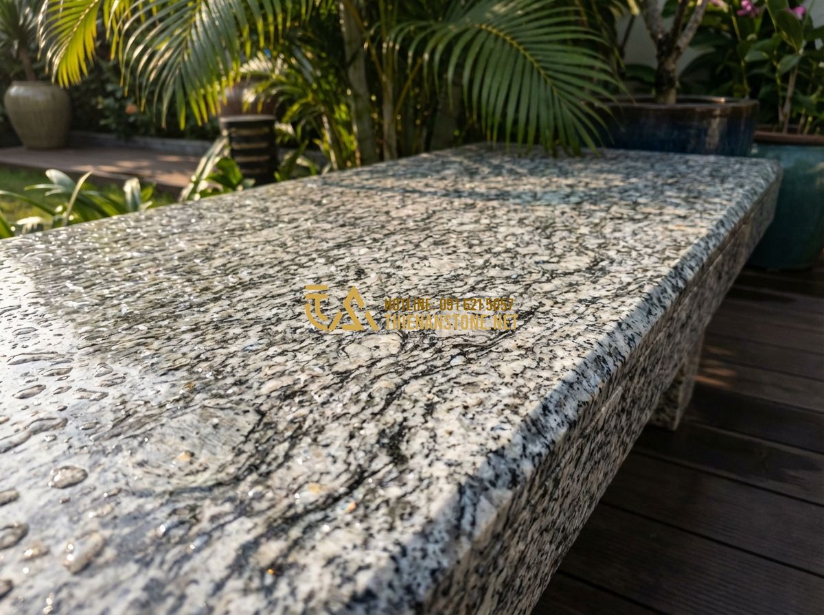 So Sánh Đá Granite Và Đá Bazan Làm Bàn Ghế Sân Vườn: Loại Nào Tốt Hơn? - Hình 2 So Sánh Đá Granite Và Đá Bazan Làm Bàn Ghế Sân Vườn: Loại Nào Tốt Hơn? - Tạo ảnh tiếng Anh: Close-up shot of a polished granite bench showing intricate c