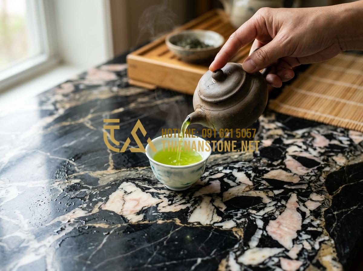 Tại sao bếp đá đun nước pha trà giúp giữ trọn hương vị trà đạo? - A close-up of a hand pouring tea from a clay pot into a porcelain cup, the tea i