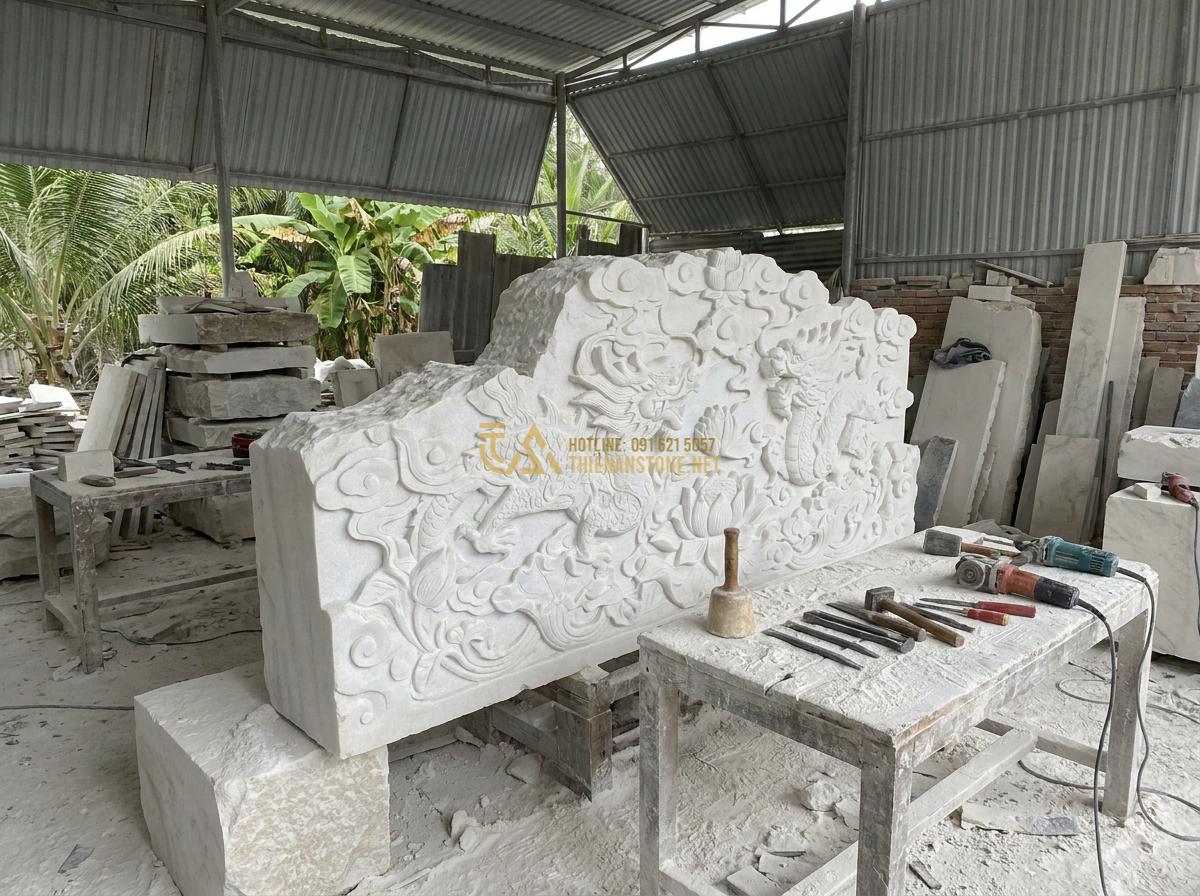 Thiết Kế & Thi Công Đài Phun Nước Bằng Đá Sân Vườn Chuẩn Phong Thủy | Quy Trình Chuyên Nghiệp - Hình 10 Thiết Kế & Thi Công Đài Phun Nước Bằng Đá Sân Vườn Chuẩn Phong Thủy | Quy Trình Chuyên Nghiệp - Master artisan sculpting detailed patterns on a high-end artistic stone water fo
