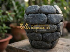 Vẻ Đẹp Thô Mộc Của Lọ Hoa Bằng Đá Cuội: Làn Gió Mới Cho Không Gian Sống Xanh - Close-up view of a rustic pebble stone flower vase showing natural irregular tex