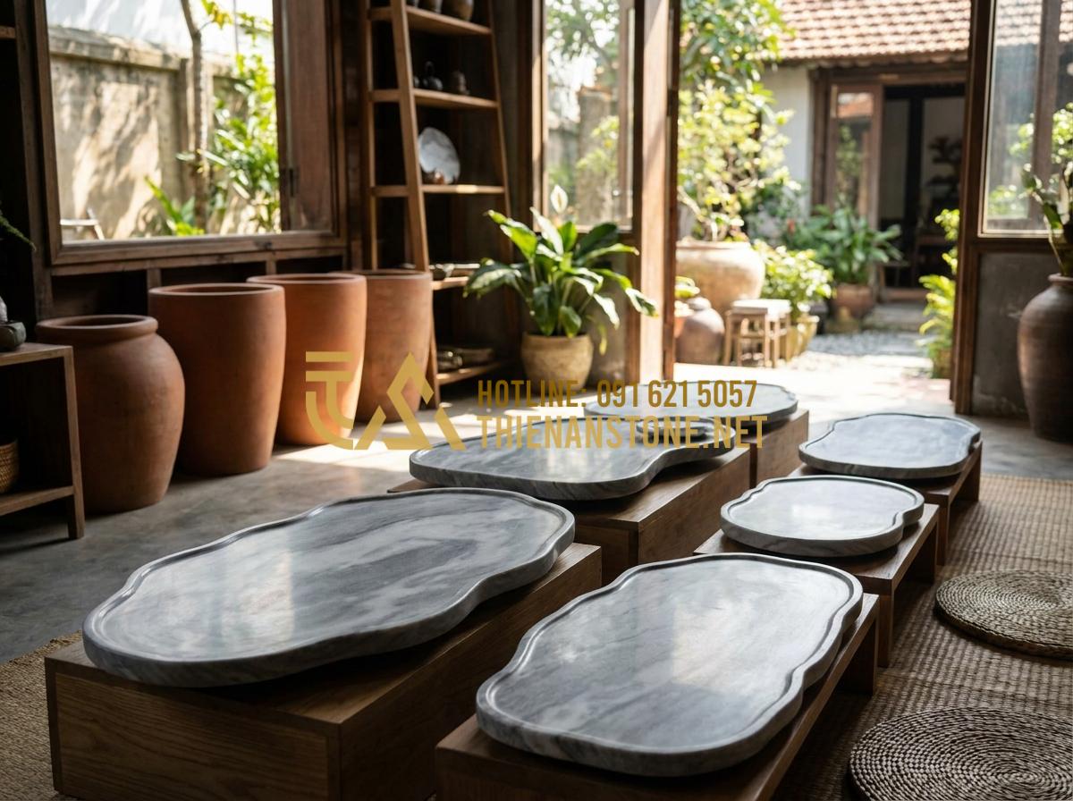 Ý Nghĩa Phong Thủy Của Khay Trà Đá: Cách Chọn Màu Đá Hợp Mệnh Gia Chủ - Various sizes of stone tea trays displayed in a showroom with different stone co